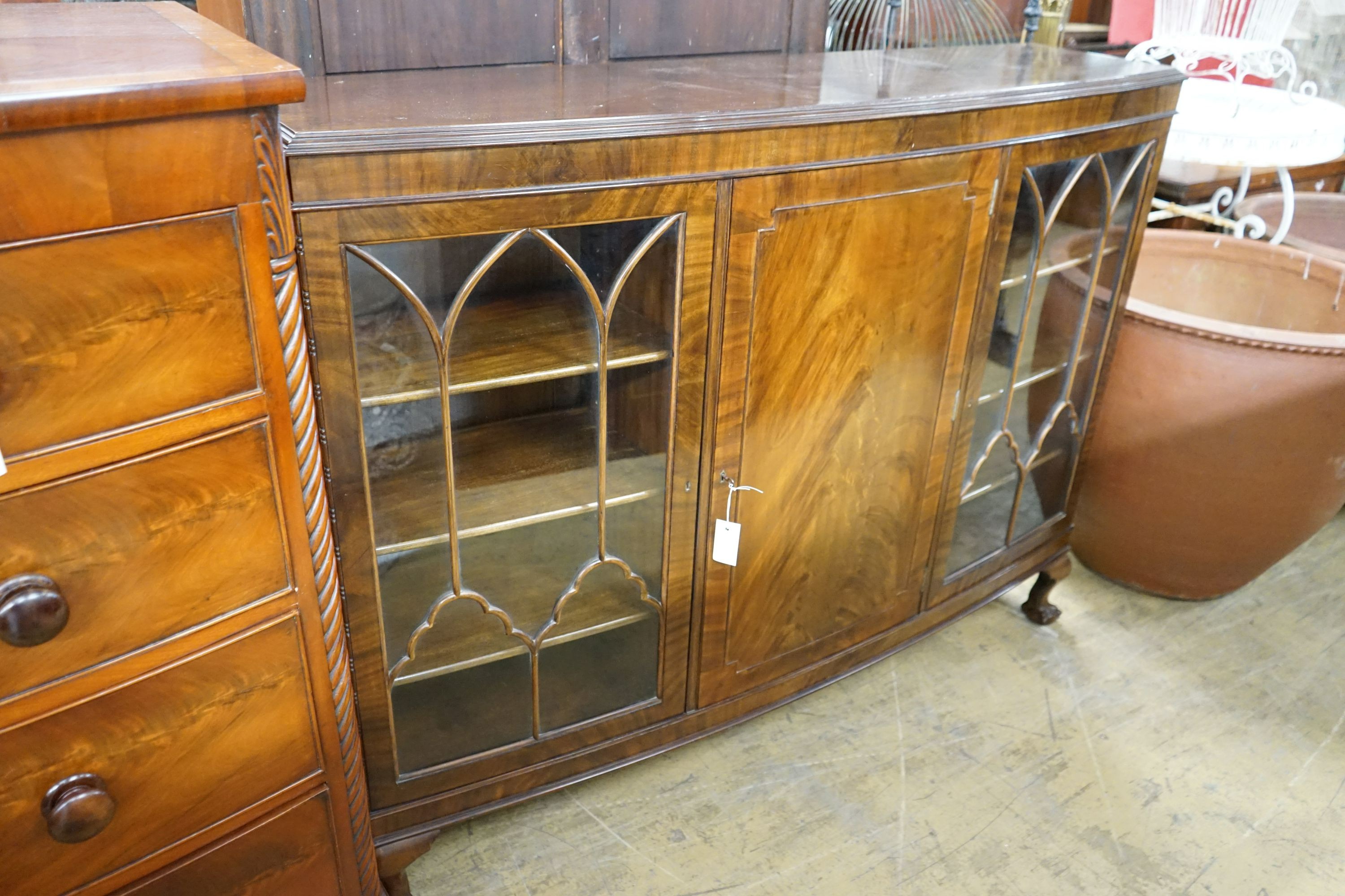 A 1920's mahogany bowfont bookcase, width 152cm, depth 39cm, height 116cm